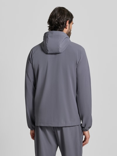 Mannenmodel draagt Regular Fit Jacke mit Logo-Print Modell 'Vibe' van Under Armour, gladde grijze stof, regular fit, rugaanzicht.