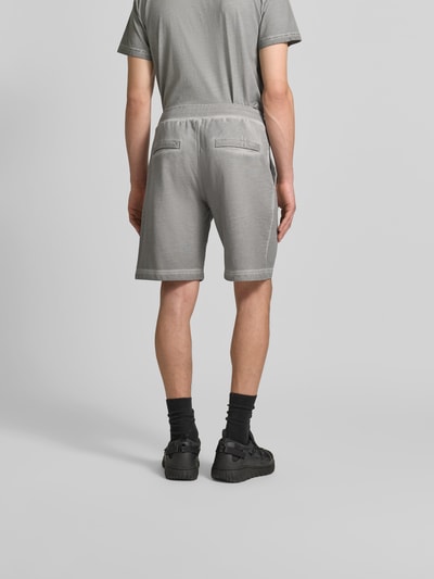 Männermodel trägt Sweatshorts aus reiner Baumwolle von Diesel in Grau mit Used-Look, Label-Print und elastischem Bund, Ganzkörperansicht Rückansicht.