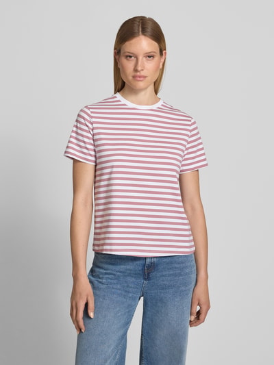 Kobiece model nosi damski t-shirt z mieszanki bawełny i elastanu VILA, krój regular fit, model 'NORA', okrągły dekolt, długość tyłu 57 cm w rozmiarze S, białe i różowe paski, tekstura gładka, widok całej sylwetki z przodu.