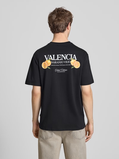 Männermodel trägt schwarzes Relaxed Fit T-Shirt aus reiner Baumwolle Modell 'TASTY' von Only & Sons mit Rücken-Print, Ganzkörperansicht Rückansicht.