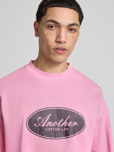 Männermodel trägt Relaxed Fit Longsleeve aus Baumwolle Modell 'Another Vintage' von ANOTHER COTTON LAB in Rosa mit Label-Print, Nahaufnahme Oberkörper. Rückenlänge bei Größe M: 63 cm, reine Baumwolle.