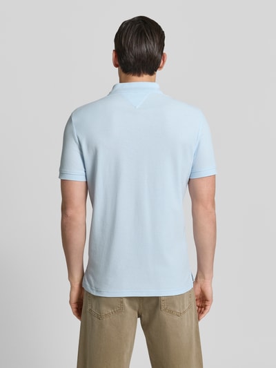 Männermodel trägt Regular Fit Poloshirt aus reiner Baumwolle von Tommy Hilfiger, Optik: Unifarben, Piqué-Struktur, Ganzkörperansicht Rückansicht.
