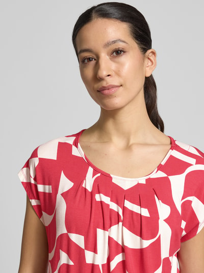 Vrouwenmodel draagt Regular Fit blouse uit viscosemix model 'Minou' van ZABAIONE, bloemen all-over print, ronde hals, elastische band, met korte mouwen, detailopname bovenlichaam.