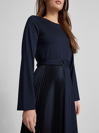 Modelka kobieca nosi Regular Fit Jersey-Kleid mit Lyocell-Anteil Modell 'TALAMO' od Weekend Max Mara, granatowa tkanina, plisowane detale, unifarb, mini długość, prosta faktura, pasek z materiału, długi rękaw, zdjęcie z przodu tułowia.