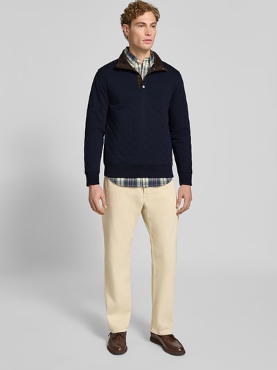 Männermodel trägt Regular Fit Troyer aus Baumwoll-Mix von GANT, jednokolorowy, krój regular fit, fakturowany wzór, aplikacja z logo, stójka, wysoki dekolt, długi rękaw, zakończenia prążkowane, dzianina dresowa, mieszanka bawełny, Ganzkörperansicht von vorne.