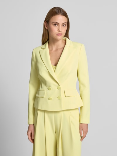 Frauenmodel trägt Blazer mit Reverskragen und doppelreihigem Knopfverschluss von Rinascimento in Hellgelb, Material-Mix, taillierter Schnitt, Nahaufnahme Oberkörper.