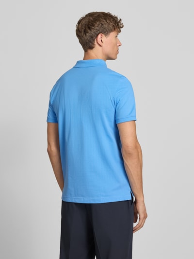 Männermodel trägt Slim Fit Poloshirt mit Label-Stitching von MCNEAL aus reiner Baumwolle in Blau, Rückenlänge 72 cm, Ganzkörperansicht Rückansicht.