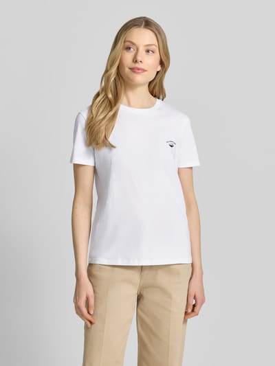 Modelka kobieca nosi T-Shirt mit Motiv-Stitching von Jake*s Casual z czystej bawełny, krój regular fit, biały kolor, okrągły dekolt, długość tyłu w rozmiarze S: 61 cm, widok całej sylwetki z przodu.