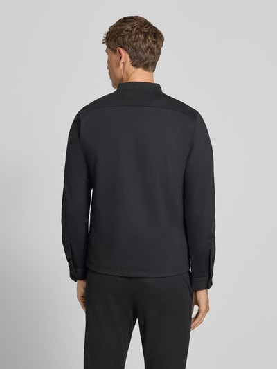 Męski model nosi Regular Fit Sweatjacke mit Stehkragen od Lindbergh, elastyczna mieszanka materiałów, wpuszczane kieszenie, krój regular fit, stójka, zamek błyskawiczny, długość tyłu w rozmiarze M: 69 cm, długość rękawów w rozmiarze M: 66 cm, kolor czarny, gładka faktura, widok całej sylwetki z tyłu