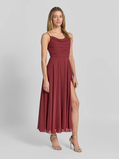 Modelka nosi sukienkę koktajlową z drapowaniami i cienkimi ramiączkami od Jake*s Cocktail, szyfon, taliowany fason, sukienka midi, szerokość w rozmiarze 36: 40 cm, długość tyłu: 107 cm, widok całej sylwetki z przodu.