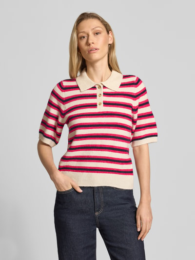 Frauenmodel trägt Regular Fit Strickpullover mit Woll-Anteil Modell 'CANNA' von Vero Moda, mehrfarbig gestreift, Polokragen, Strickstruktur, Ganzkörperansicht von vorne.