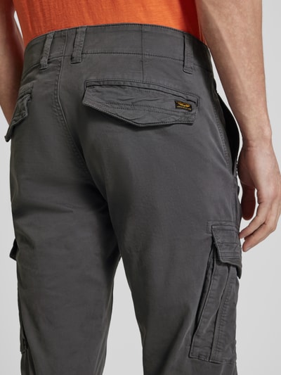 Męski model nosi Spodnie cargo z wyhaftowanym logo od PME Legend, mieszanka bawełny i elastanu, krój slim fit, detal tyłu, zbliżenie