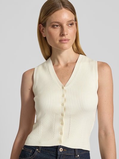 Frauenmodel trägt Strickweste aus Viskose-Mix mit V-Ausschnitt von Jake*s, Slim-Fit, Ripp-Optik, Knopfleiste, Rückenlänge 50 cm, Nahaufnahme Oberkörper.