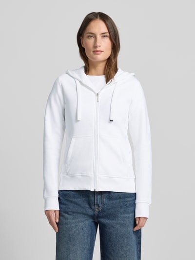 Kobiece modelka nosi bluzę rozpinaną z mieszanki bawełny od Christian Berg Woman, luźny krój, kaptur, tunel, wpuszczane kieszenie, białe, prążkowane wykończenia, zamek błyskawiczny, widok na cały korpus z przodu.