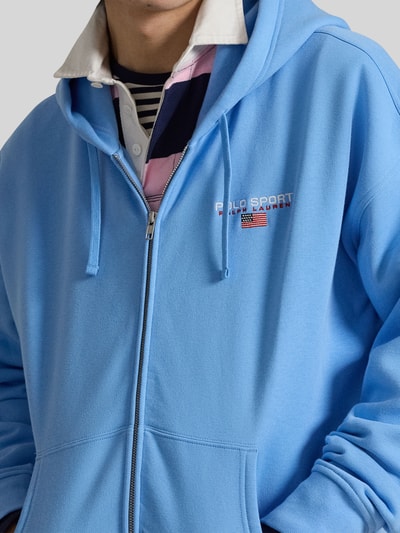 Männermodel trägt Relaxed Fit Sweatjacke aus Baumwoll-Mix von Polo Ralph Lauren in Hellblau, unifarben, Nahaufnahme Oberkörper.