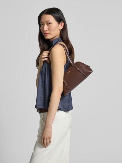 Modelka nosi Henkeltasche mit Label-Applikation Modell 'SYNDRA_DUFFLE' od HUGO z ekoskóry, kolor brązowy, detal w postaci logo, widok z boku, półzbliżenie.
