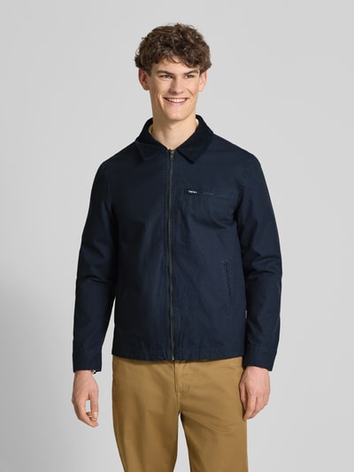 Männermodel trägt Jacke mit Brusttasche Modell 'FONTANA' von Blend in Dunkelblau, Regular Fit, Umlegekragen, Ganzkörperansicht von vorne.