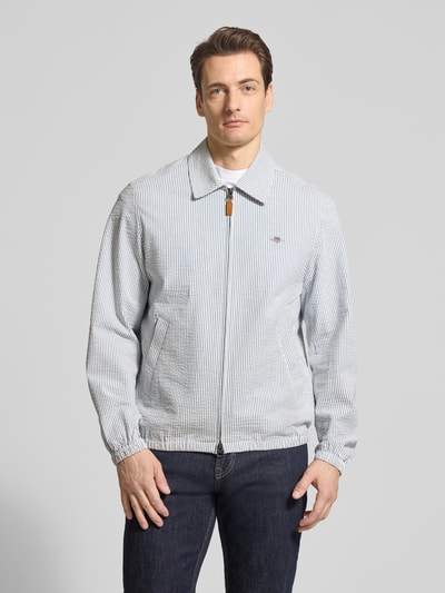 Männermodel trägt Jacke mit Zweiwege-Reißverschluss und Label-Stitching von Gant, Baumwoll-Elasthan-Mix, Regular-Fit, Ganzkörperansicht von vorne.