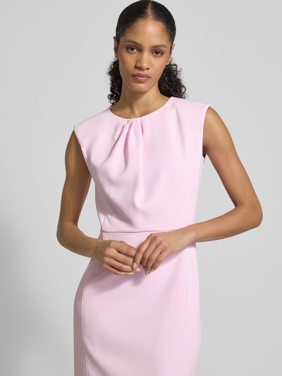 Modelka nosi Regular Fit Midikleid mit Gehschlitz von Marc Cain, elastyczna mieszanka materiałów, okrągły dekolt, krój bez rękawów, zakładane fałdy, wszyty zamek błyskawiczny, szerokość w rozmiarze 36: 42 cm, długość tyłu 108 cm, jasnoróżowy kolor, gładka tekstura, półzbliżenie górnej części ciała