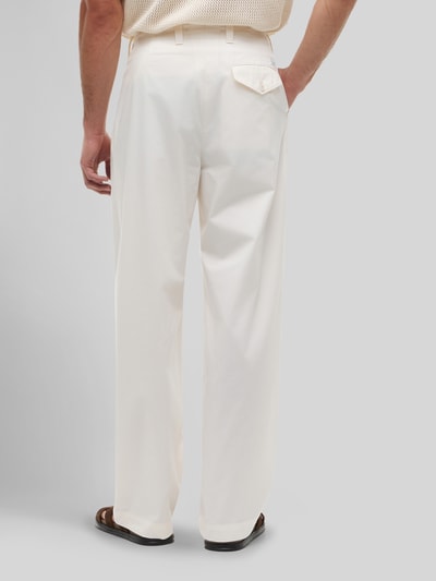 Męski model nosi Loose Fit Hose mit Bundfalten od Tommy Hilfiger, efekt: jednolity kolor, materiał: bawełna, zapięcie na guzik, kieszeń z patką, Ganzkörperansicht Rückansicht.