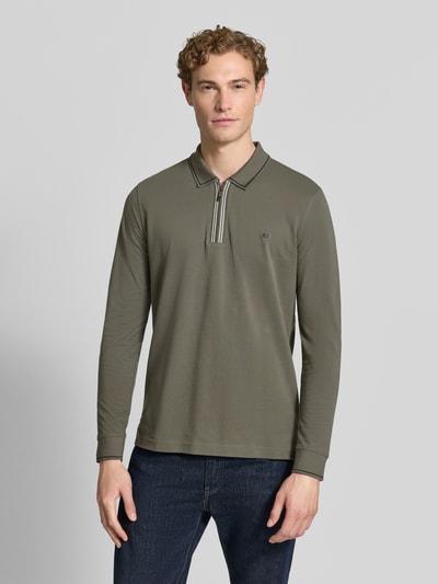 Männermodel trägt Slim Fit Poloshirt mit Reißverschluss von Christian Berg Men aus reiner Baumwolle, olivgrün, Longsleeve, Ganzkörperansicht von vorne.
