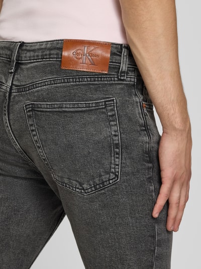 Männermodel trägt Slim Fit Jeans aus Baumwoll-Mix von Calvin Klein Jeans in dunklem Grau, Nahaufnahme Rückansicht.