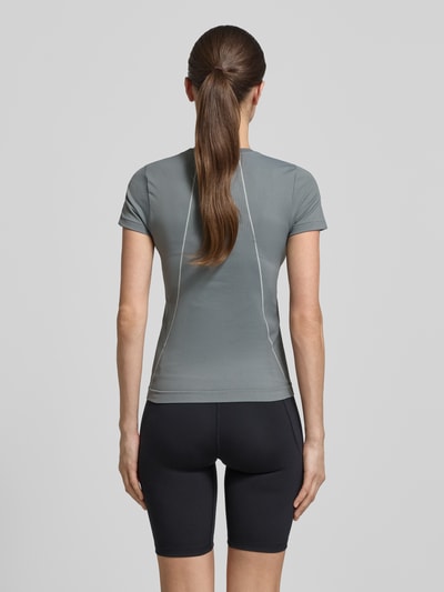 Vrouwenmodel draagt T-shirt met ronde hals en logo van Under Armour, materiaalmix met stretch, slim fit, ruglengte maat S 54 cm, volledig silhouet rugaanzicht.