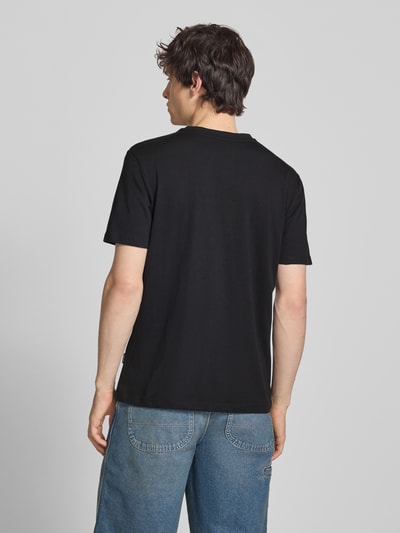 Männermodel trägt T-Shirt mit Stitching Modell 'KAAN' von Blend aus reiner Baumwolle, Regular Fit, schwarze Farbe, Ganzkörperansicht Rückansicht.