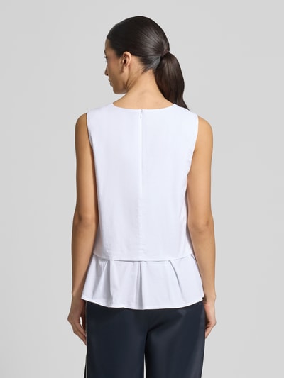 Modelka nosi Blusenshirt mit Volantsaum und Rundhalsausschnitt von Marc Cain, mieszanka bawełny i wiskozy, prosty krój, dół obszyty falbaną, zamek błyskawiczny z tyłu, długość tyłu w rozmiarze 36: 59 cm, widok całej sylwetki z tyłu.