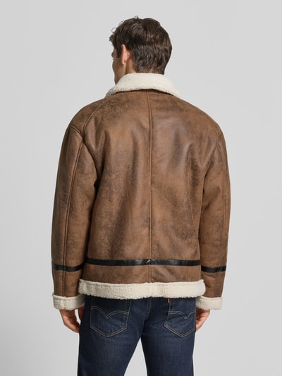 Männermodel trägt Regular Fit Jacke in Leder-Optik von Lindbergh in Braun mit Kunstfellbesatz und schwarzem Detailstreifen, Ganzkörperansicht Rückansicht.