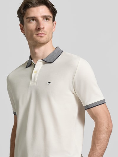Männermodel trägt Modern Fit Poloshirt mit Stitching von Fynch-Hatton in Creme mit kontrastfarbigem Kragen, aus Baumwolle, Nahaufnahme Oberkörper.