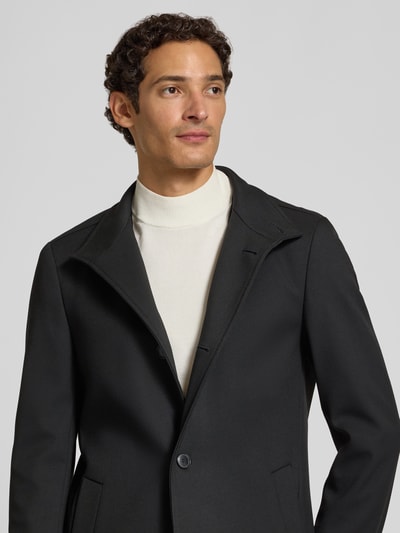 Männermodel trägt schwarzen Slim Fit Mantel mit Viskose-Anteil Modell 'H-Hyde-SU' von BOSS, Herren Mantel, Nahaufnahme Oberkörper.