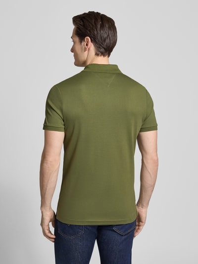 Männermodel trägt Regular Fit Poloshirt aus pure katoen Model 'LIQUID COTTON' van Tommy Hilfiger met mêlee look, logostitching, polokraag, korte mouw, geribde mouwboord, rompzoom met zijsplitten, ganzkörperansicht rückansicht.