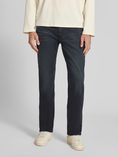 Männermodel trägt Slim Fit Jeans aus Baumwoll-Mix Modell 'MIDNIGHT EMERALD' von Calvin Klein Jeans in Dunkelblau, Ganzkörperansicht von vorne. Herren Slim Fit Jeans von Calvin Klein Jeans.