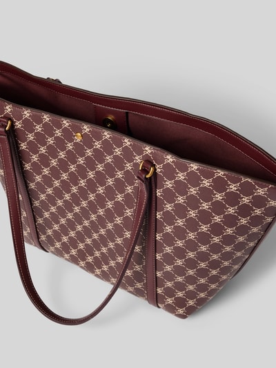 Produktfoto, Tote Bag mit Magnetverschluss Modell 'PORTA' von MANGO, weinrotes Kunstleder mit cremefarbenem Allover-Label-Print, dezente Struktur, schmale Schulterriemen, Maße 50x30x14 cm, 62 cm lange Riemen, Kontrastnaht und goldfarbener Magnetverschluss.