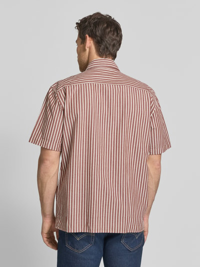Männermodel trägt Relaxed Fit Freizeithemd aus reiner Baumwolle Modell 'STUART' von SELECTED HOMME, gestreiftes Allover-Muster, Seersucker-Textur, Ganzkörperansicht Rückansicht.