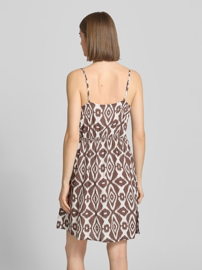 Vrouwenmodel draagt Leicht ausgestelltes Minikleid aus reiner Viskose Modell 'TALA' van Pieces met all-over motief, licht uitlopend, minilengte, V-hals, verstelbare spaghettibandjes, mouwloos, recht zoom, materiaal: zuiver viscose. Ganzkörperansicht Rückansicht.