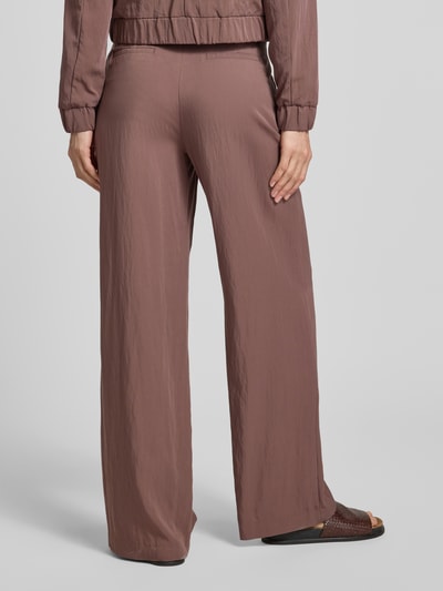 Männermodel trägt Hose mit französischen Eingrifftaschen von Christian Berg Woman Selection, viskose-mix, krój loose fit, kolor brązowy, szeroka nogawka, szerokość w rozmiarze 36: 39 cm, długość wewnętrzna nogawki: 81 cm, widok całej sylwetki od tyłu.