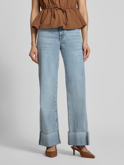 Frauenmodel trägt Wide Fit Jeans aus reiner Baumwolle Modell 'Rey' von GUESS, hellblau, 5-Pocket-Design, Ganzkörperansicht von vorne.