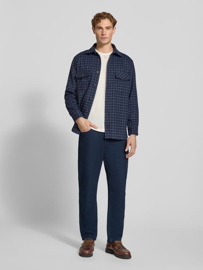 Männermodel trägt Regular Fit Overshirt mit Karo-Muster von Christian Berg Men in Dunkelblau zu heller Hose, Herren Freizeithemd, Ganzkörperansicht von vorne.