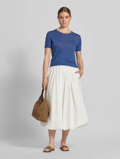 Frauenmodel trägt Regular Fit Strickpullover aus reinem Leinen Modell 'PANCONE' von Weekend Max Mara in Optik: Unifarben, Blau, Kurzarm, Crew Neck, Materialverarbeitung: Strick, kombiniert mit weißem Rock, Ganzkörperansicht von vorne.