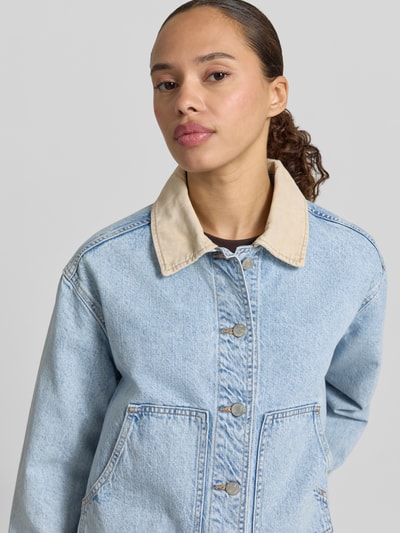 Frauenmodel trägt Cropped Jeansjacke mit Umlegekragen von GAP aus Reiner Baumwolle, helle Waschung, sichtbare Knopfleiste, Eingrifftaschen, Nahaufnahme Oberkörper.