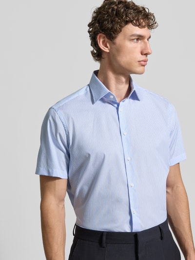 Männermodel trägt Regular Fit Business-Hemd aus Baumwolle mit Kentkragen von Christian Berg Men, feine blaue Streifen, Nahaufnahme Oberkörper.