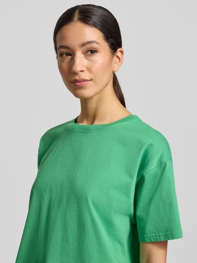 Frauenmodel trägt Loose Fit T-Shirt aus reiner Baumwolle Modell 'VALLEY' von American Vintage in kräftigem Grün, Nahaufnahme Oberkörper.