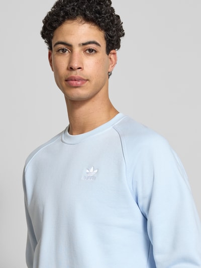 Męski model nosi Sweatshirt mit Label-Stitching od adidas Originals, bawełniany miks, luźny krój, niebieski, widok na górną część ciała z przodu.