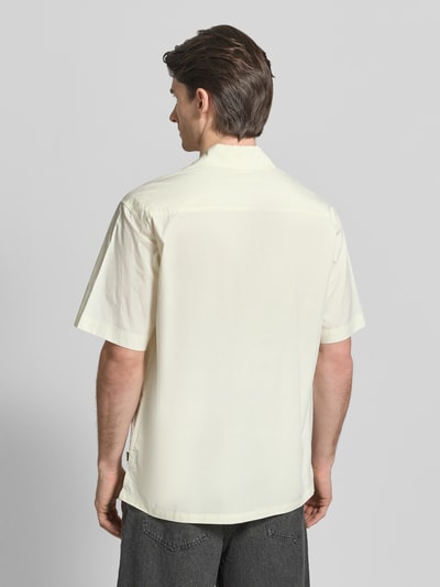 Männermodel trägt Regular Fit Freizeithemd mit Label-Print Modell 'Banks' von WOODBIRD, cremefarben, Kentkragen, Ganzkörperansicht Rückansicht, Rückenlänge 76 cm, Schulterbreite 52 cm, Ärmellänge 28 cm.