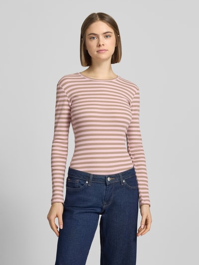 Frauenmodel trägt Slim Fit Langarmshirt aus Baumwoll-Mix von Pieces, gestreift, rosa-weiß, Rippstrick, Rundhals, Ganzkörperansicht von vorne.
