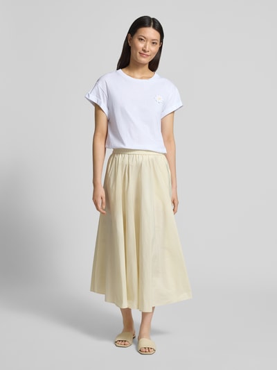 Modelka kobieca ma na sobie t-shirt z florystyczną aplikacją i stałą zakładką na rękawach od Rich & Royal, damski t-shirt z bawełny ekologicznej, krój straight fit, okrągły dekolt, długość tyłu 60 cm w rozmiarze S, widok całej sylwetki z przodu.