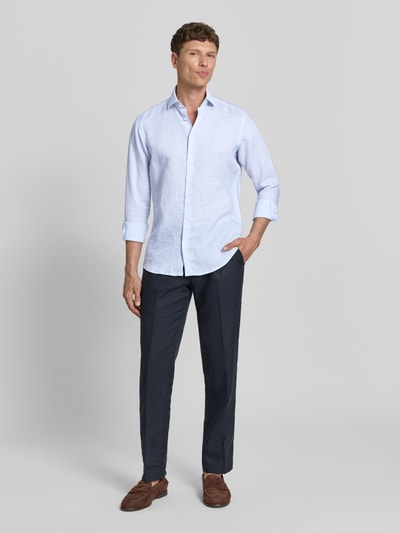 Männermodel trägt Regular Fit Leinenhemd mit Kentkragen von Christian Berg Men in Hellblau, mit Knopfleiste, Sportmanschetten, abgerundetem Saum und Reine Leinen; Rückenlänge 77 cm, Schulterbreite 41 cm, Ärmellänge 64 cm bei Größe 39/40, Ganzkörperansicht von vorne.