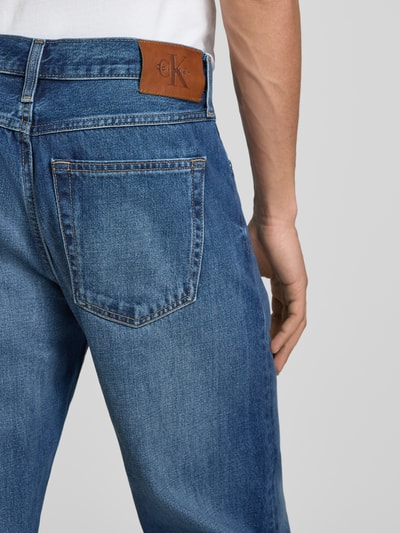 Männermodel trägt Straight Fit Jeans mit Label-Detail von Calvin Klein Jeans, Reine Baumwolle, Used-Look, Ganzkörperansicht Rückansicht.